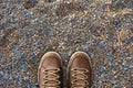 Selfie feet in brown leather shoes on stones floor, pebble beach. Foot and legs seen from above. Top view, copyspace Royalty Free Stock Photo