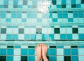 Selfie of feet and legs in green swimming pool and waves background or texture. Top view. Beautiful young female barefoot under Royalty Free Stock Photo