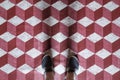 Selfie of feet with sneaker shoes on art pattern tiles floor red and white 3d cube