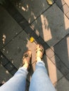 Selfie of female feet in sandals and jeans on the pavement. Royalty Free Stock Photo