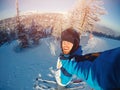 Selfie Guy sportsman goes on normal skiing on ski slope with action camera. Sunset. winter Royalty Free Stock Photo