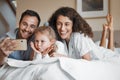 Selfie, happy and family on a bed together for bonding on a weekend morning at modern home. Smile, goofy and girl child