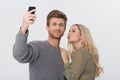 Selfie, happy and young couple in a studio for memory with love, care and sweet relationship. Smile, kiss and man and Royalty Free Stock Photo