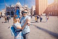 Selfie lover couple taking photo travel Venice, Italy against backdrop St Mark Square in blue venetian mask Royalty Free Stock Photo