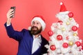 Selfie near xmas tree. Capture happy memory. new year party. merry christmas. bearded man search gift online Royalty Free Stock Photo
