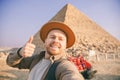 Selfie photo archaeologist man in hat with camel background pyramid of Egyptian Giza, sunset Cairo, Egypt Royalty Free Stock Photo