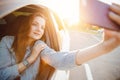 Selfie photo of beautiful girl driving car sunset. Concept driver travel