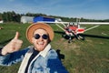 Selfie photo happy tourist man pilot in hat and glasses background white aircraft cockpit. Concept training private Royalty Free Stock Photo