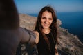 Selfie-portrait of a young woman against the background of the sea at the cliff. The girl smiles at the camera. The Royalty Free Stock Photo