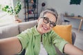 Selfie shooting blogger entrepreneur businesswoman wear green shirt smiling demonstrating in cadre her modern interior Royalty Free Stock Photo