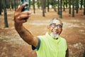 Selfie, smile and senior man hiking for health, wellness or cardio training on a mountain. Happy, nature and excited