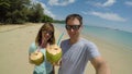 SELFIE: Smiling couple enjoying tasty coconut juice while on the idyllic beach.