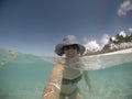 Selfie of a smiling middle aged woman in hat and shades in sea a Royalty Free Stock Photo