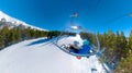 SELFIE: Snowboarding couple rides the chairlift and observe the snowy mountains Royalty Free Stock Photo