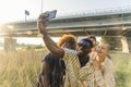 Selfie taken outdoors. Interracial group of four people - two casually dressed women and men - taking a selfie. Handsome Royalty Free Stock Photo