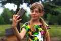 Selfie. A ten year old girl poses and takes a selfie by hand. Beautiful teenage girl takes selfie while standing alone Royalty Free Stock Photo