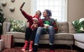 Selfie time. a cheerful young couple holding their pet dogs while taking a selfie and being seated on a sofa during