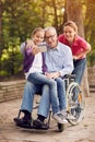 selfie time- granddaughter, daughter and disabled man in wheelchair .