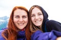 Happy two young girls taking self portrait photo hiking. Two friends on a camping trip smiling at the camera Royalty Free Stock Photo