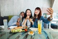 Selfie time, lunch and friendship concept. Pretty red haired girl taking a picture by the cell phone with her friends Royalty Free Stock Photo