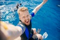 Selfie tourist man in flippers and wetsuit diver to dive into sea on boat. Concept diving trip Egypt ocean swim
