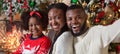 Cheerful afro family taking selfie while celebrating Christmas at home Royalty Free Stock Photo