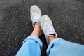 Selfie White Shoes. Close Up Woman Wear White Sneakers and Blue Jeans on Concrete Road Background