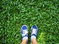 Selfie woman feet wearing blue sneaker on green grass