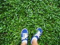 Selfie woman feet wearing blue sneaker on green grass