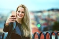 Selfies that let the world know shes arrived. a young woman using a cellphone to take selfies in the city.