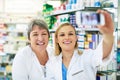 Selfies - the new way of self promotion. two happy pharmacists taking a selfie together in a chemist.