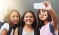 Selfies at school. Three school friends taking a self-portrait with their smartphone. Royalty Free Stock Photo
