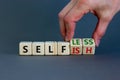 Selfish or selfless symbol. Businessman turns cubes and changes the word `selfish` to `selfless`. Beautiful grey background, c