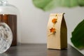 Selfmade gift box out of old beverage carton decorated with star shaped cut out dried roange peel standing on black wooden shelf