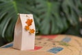 Selfmade gift box out of old beverage carton decorated with star shaped cut out dried roange peel standing on coffee bean bag with