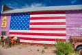 SELIGMAN, AZ - JUNE 29, 2018: Old rusty vintage truck under a painted american flag on the wall Royalty Free Stock Photo