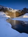 Seljalandsfoss waterfall, Iceland. Icelandic winter landscape. High waterfall and rocks. Snow and ice.