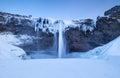 Seljalandsfoss waterfall, Iceland. Icelandic winter landscape.  High waterfall and rocks. Snow and ice. Powerful stream of water f Royalty Free Stock Photo