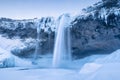 Seljalandsfoss waterfall, Iceland. Icelandic winter landscape.  High waterfall and rocks. Snow and ice. Powerful stream of water f Royalty Free Stock Photo