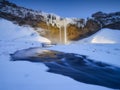 Seljalandsfoss waterfall, Iceland. Icelandic winter landscape.  High waterfall and rocks. Snow and ice. Powerful stream of water f Royalty Free Stock Photo