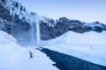 Seljalandsfoss waterfall, Iceland. Icelandic winter landscape. High waterfall and rocks. Snow and ice.