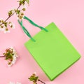 sell concept. green shopping bag on a pink background. decorating with spring flowers Royalty Free Stock Photo