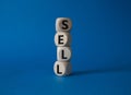 Sell symbol. Concept word Sell on wooden cubes. Beautiful blue background. Business and Sell concept. Copy space