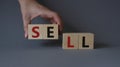 Sell symbol. Concept word Sell on wooden cubes. Businessman hand. Beautiful grey background. Business and Sell concept. Copy space