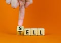 Sell or tell symbol. Businessman turns a wooden cube and changes the concept word Tell to Sell. Beautiful orange background, copy Royalty Free Stock Photo
