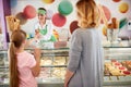 Seller in bakery gives ice cream to girl Royalty Free Stock Photo