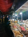Seller and buyer nasi kucing or angkringan, junk food, gorengan, small size night street food at yogyakarta