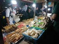 Seller and buyer nasi kucing or angkringan, junk food, gorengan, small size night street food at yogyakarta