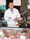 Seller at counter with jamon and wursts