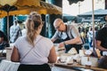 Seller and customer at a cheese stand in Borough Market, London, UK.